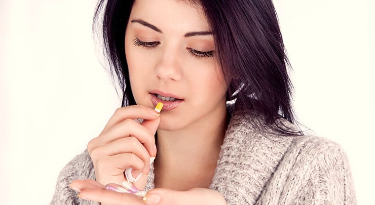 Woman taking antibiotics for her tummy tuck recovery.