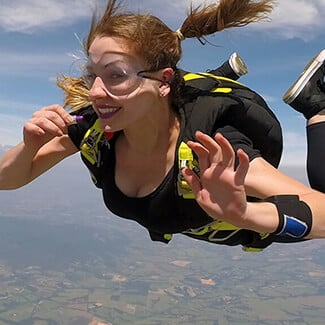 Woman skydiving and smiling.