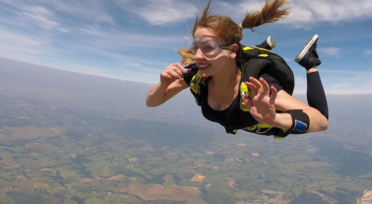 Woman skydiving and smiling.