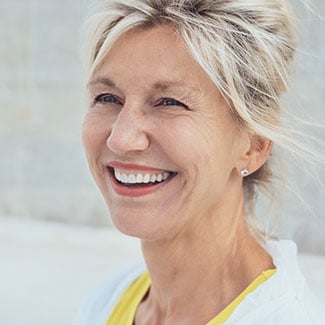 Smiling older woman on beach.