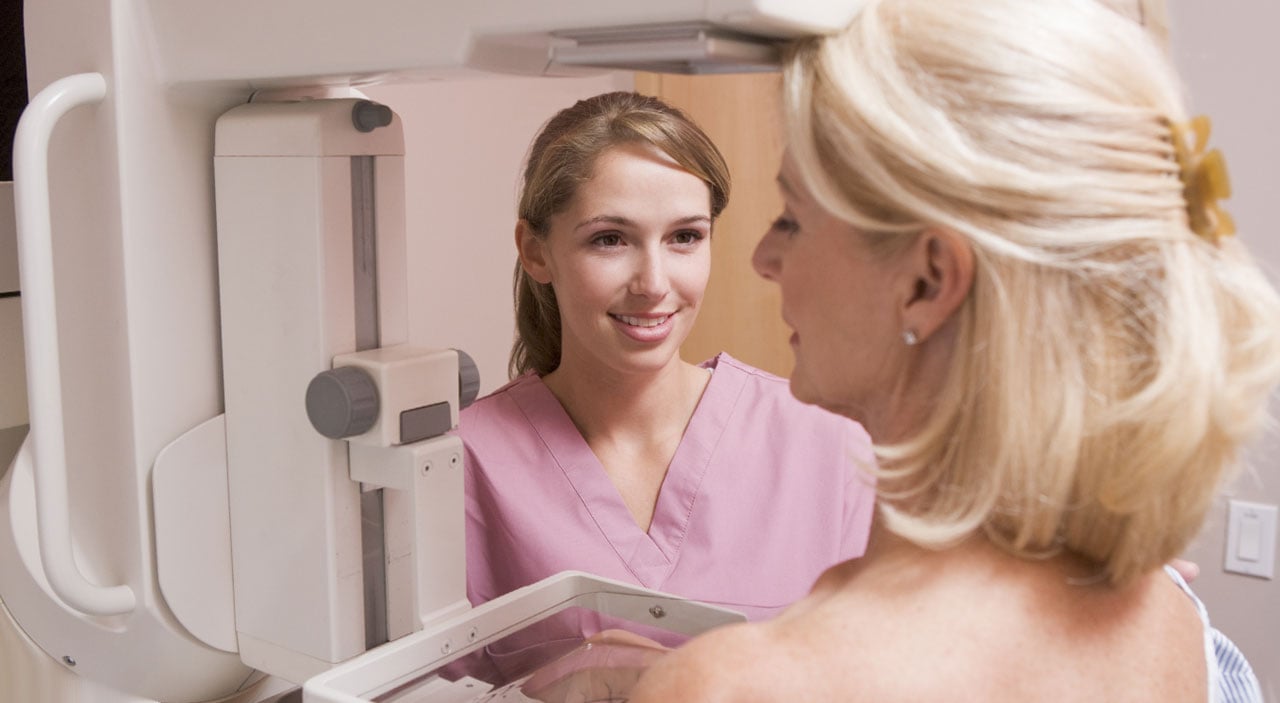 Female mammogram technician smiling at patient.