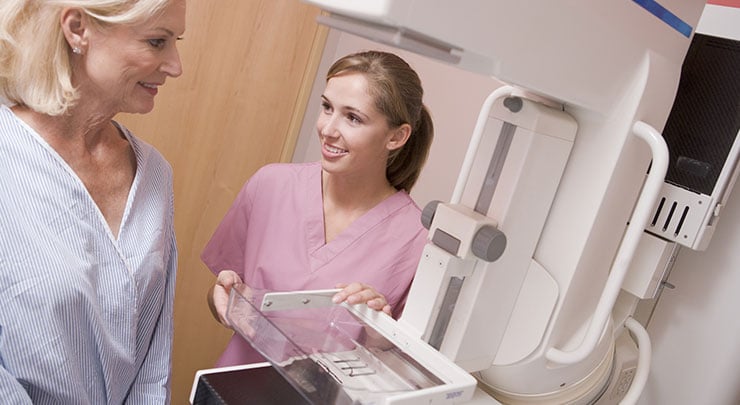 Woman with breast implants getting a mammogram.