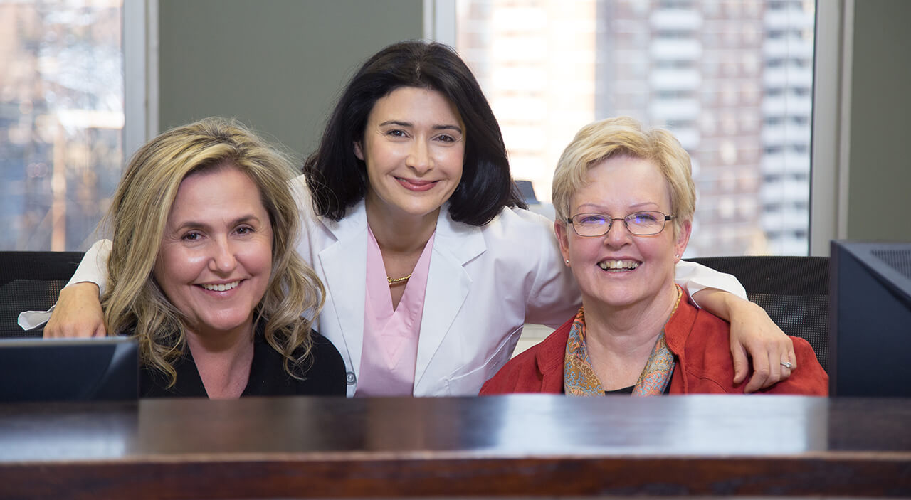 Toronto plastic surgeon Dr. Leila Kasrai with patient care coordinator Eva Coholic smiling.