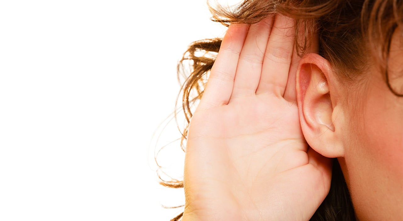 Woman wiht hand up to her prominent ear.