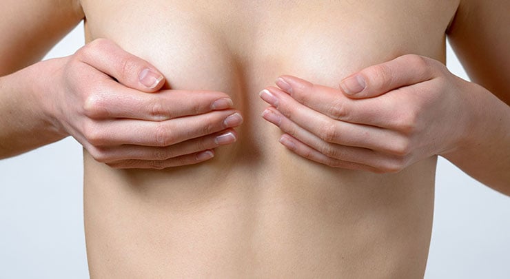 Woman holding her breasts.